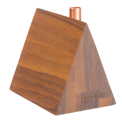 A little wooden a-frame house candlestick holder with a copper chimney.