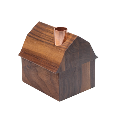 A tiny decorative wooden barn with a copper chimney.