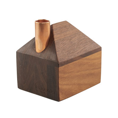 A tiny decorative wooden house with a copper chimney.